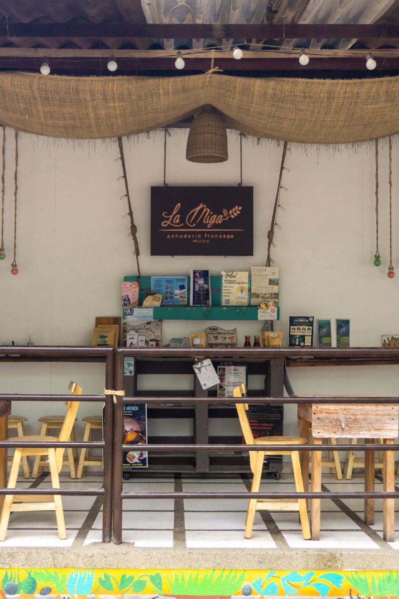 La Miga Bakery interior with tables and a stand for different activities offered in Minca La Miga Bakery interior with tables and a stand for different activities offered in Minca
