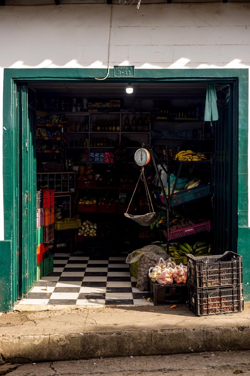 Small grocery store in Guadalupe, Santander. An old weight, a couple of plastic trays and bags with produce lay in the front of the store. Small grocery store in Guadalupe, Santander. An old weight, a couple of plastic trays and bags with produce lay in the front of the store.