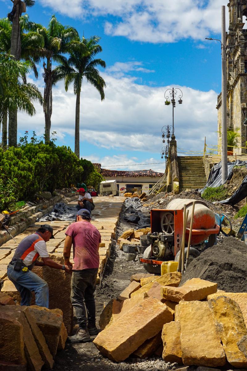 Town workers laying what looks like sandstone on the street between the church and the main park of Guadalupe, Santander Town workers laying what looks like sandstone on the street between the church and the main park of Guadalupe, Santander