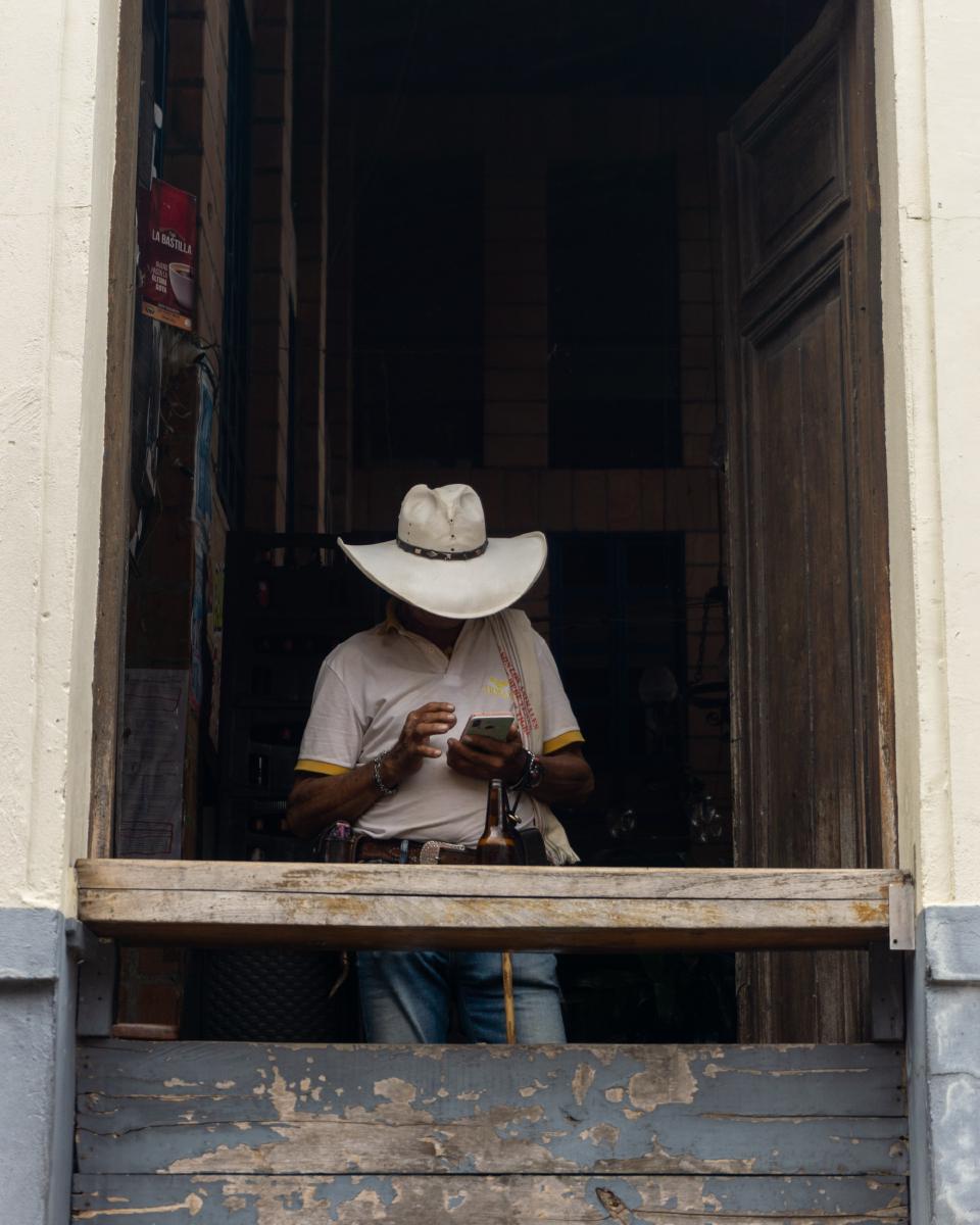Hombre con sombrero puesto, parado en la ventada de uno de los bares de Fredonia. Hombre con sombrero puesto, parado en la ventada de uno de los bares de Fredonia.