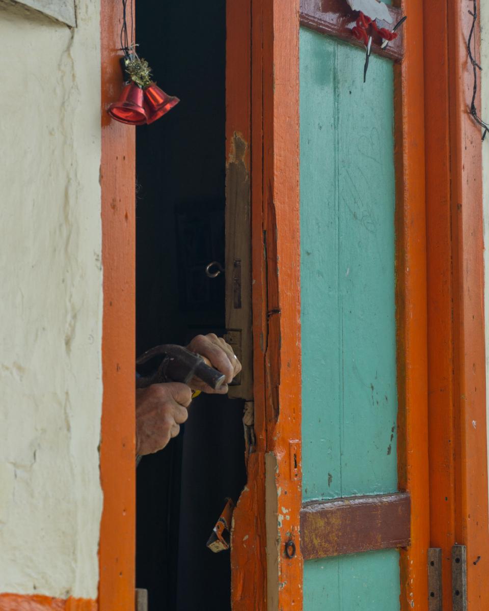 Hombre haciendo reparaciones en una de las coloridas puertas de Jericó. Hombre haciendo reparaciones en una de las coloridas puertas de Jericó.