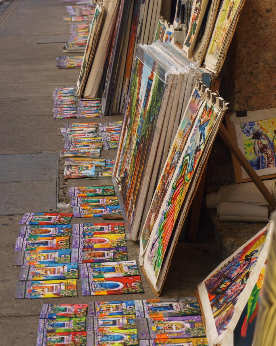 Cuadros de pintura a la venta en el piso, en una de las calles del Centro de Cartagena