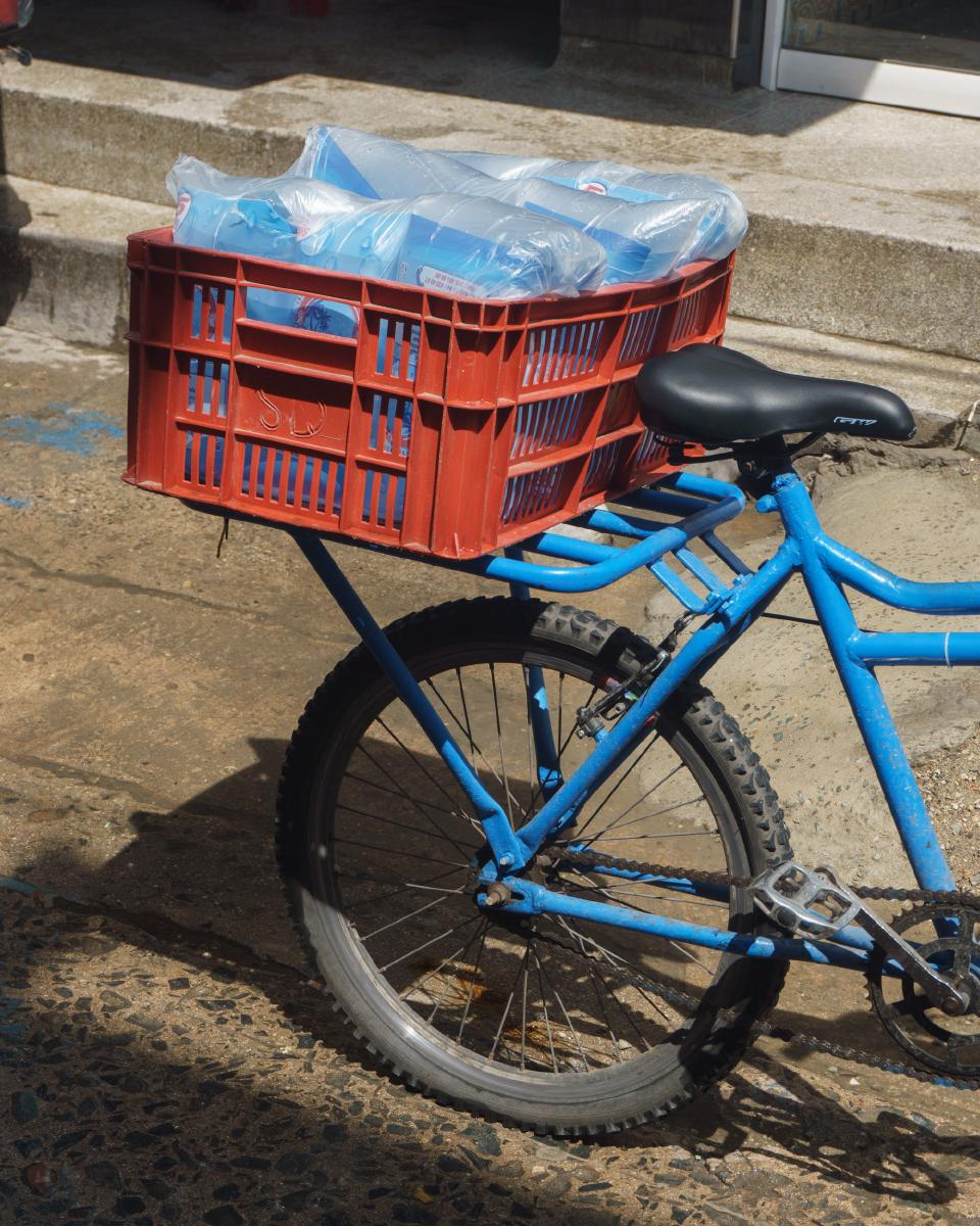 Bicicleta con canasta llena de bolsas de agua estacionada en la calle